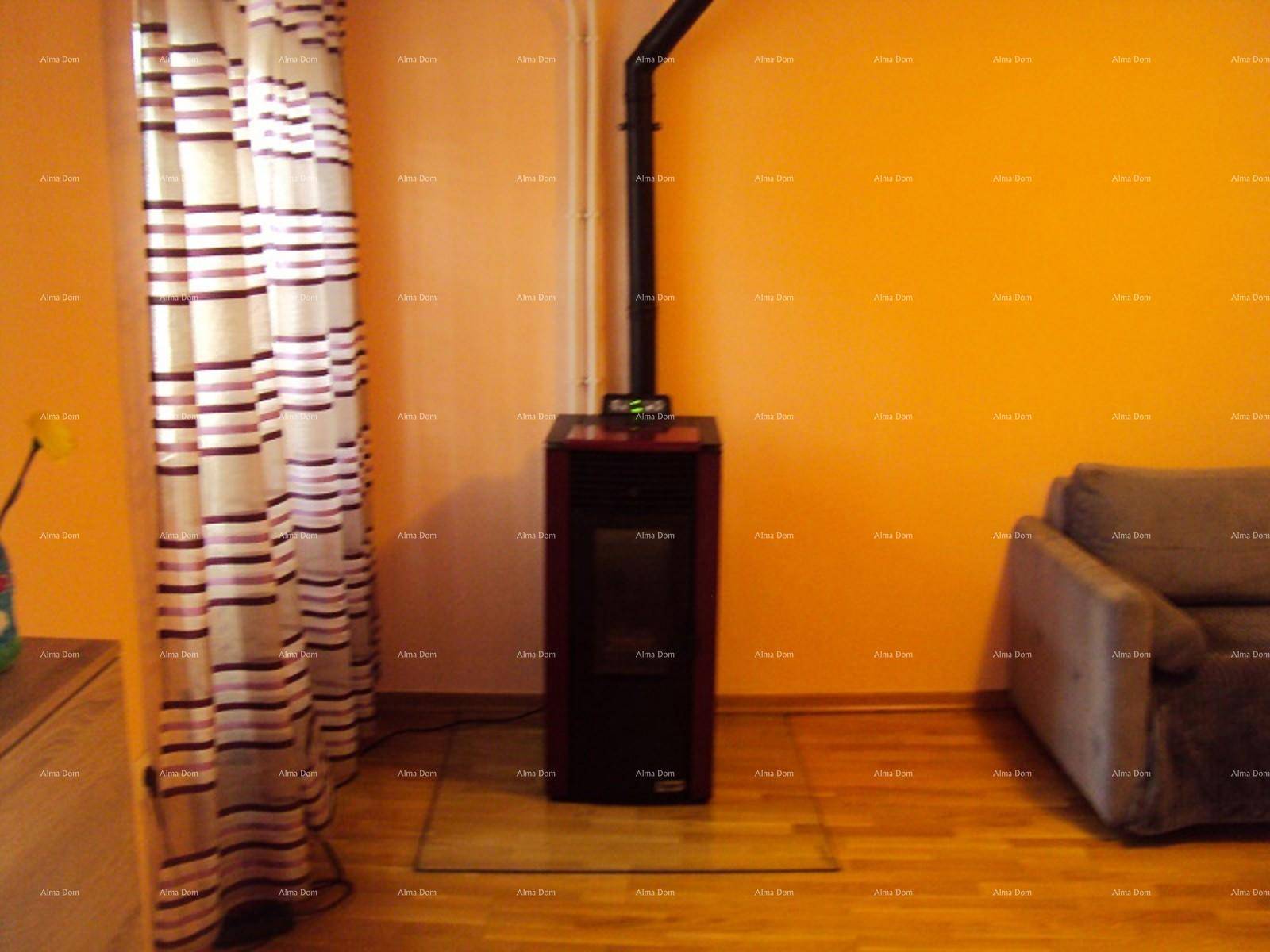 Wohnzimmer mit orangefarbenen Wänden, Holzboden und einem modernen Holzofen.