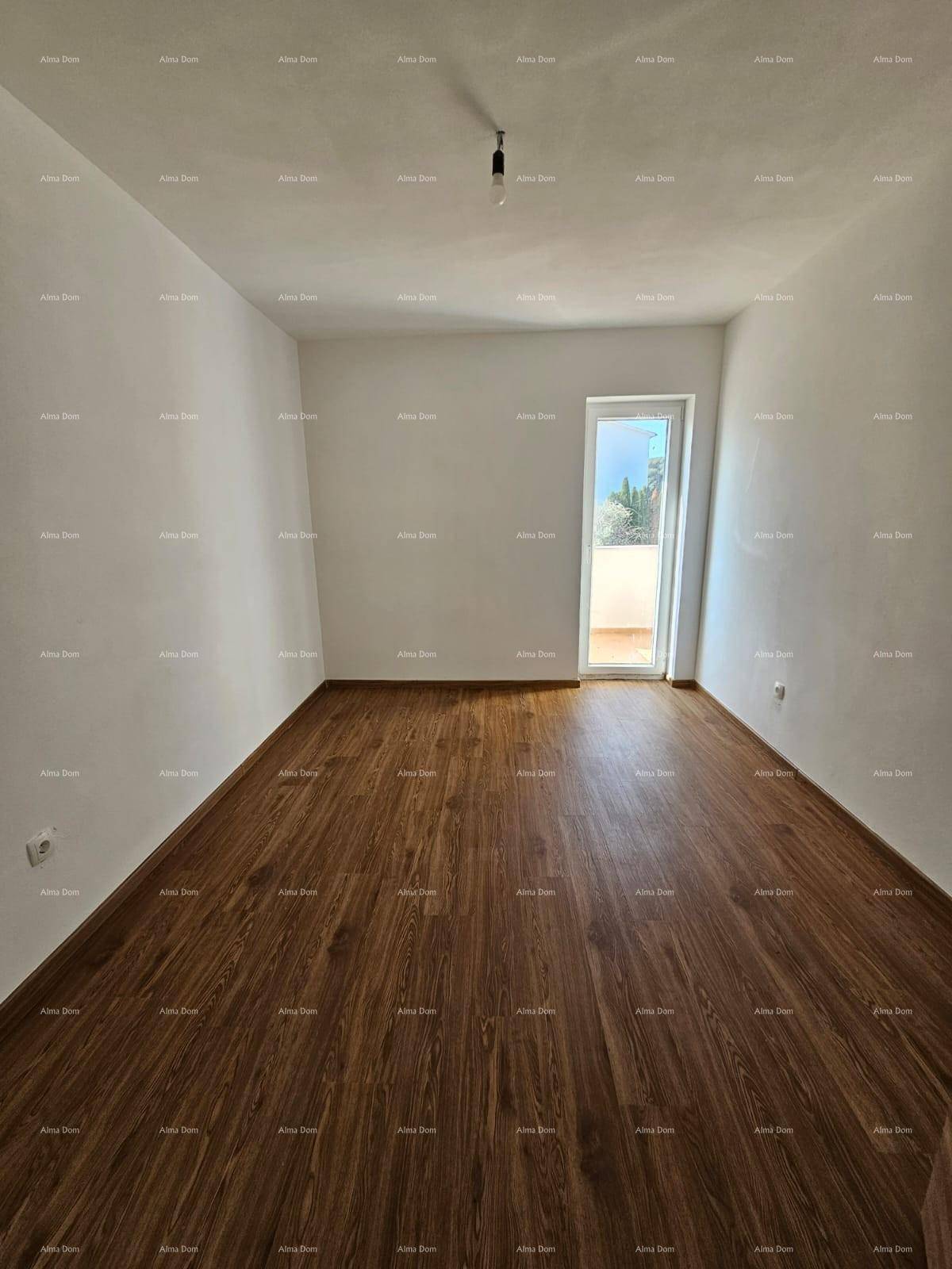 Leeres Schlafzimmer mit Laminatboden und einer Tür, die zu einem Außenbereich führt.