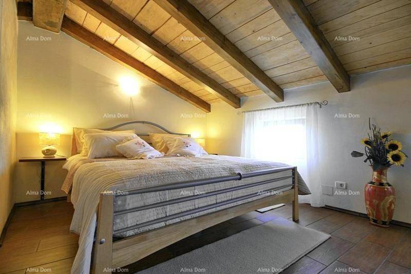 Helles Schlafzimmer im Dachgeschoss mit Holzbalken, Holzboden und gemütlichem Bett.