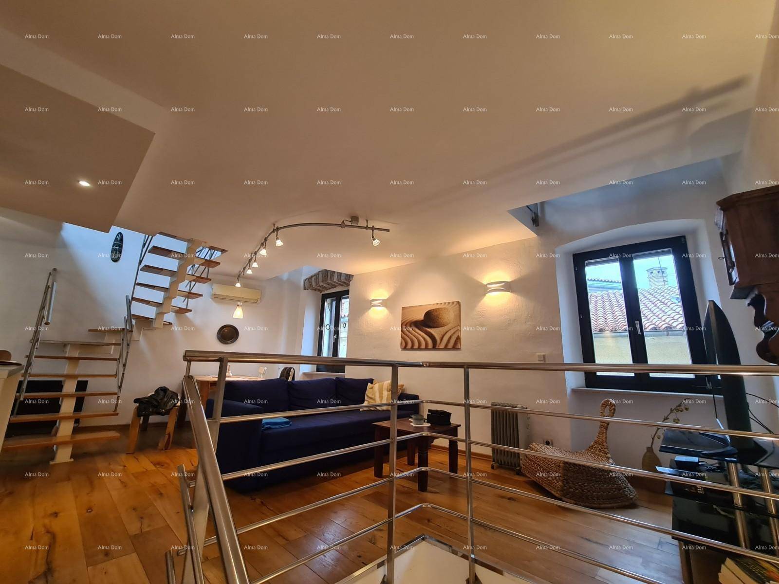 Heller Wohnbereich mit Holzboden, blauem Sofa und offener Treppe, modern beleuchtet.