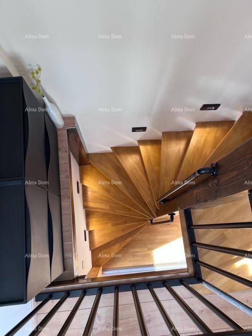 Elegante Holzwendeltreppe mit schwarzem Geländer, die die verschiedenen Ebenen des Hauses verbindet.
