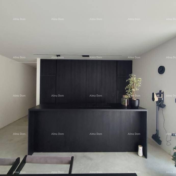 Moderne schwarze Kücheninsel mit minimalistischem Design und integrierter Arbeitsfläche in einem offenen Raum.