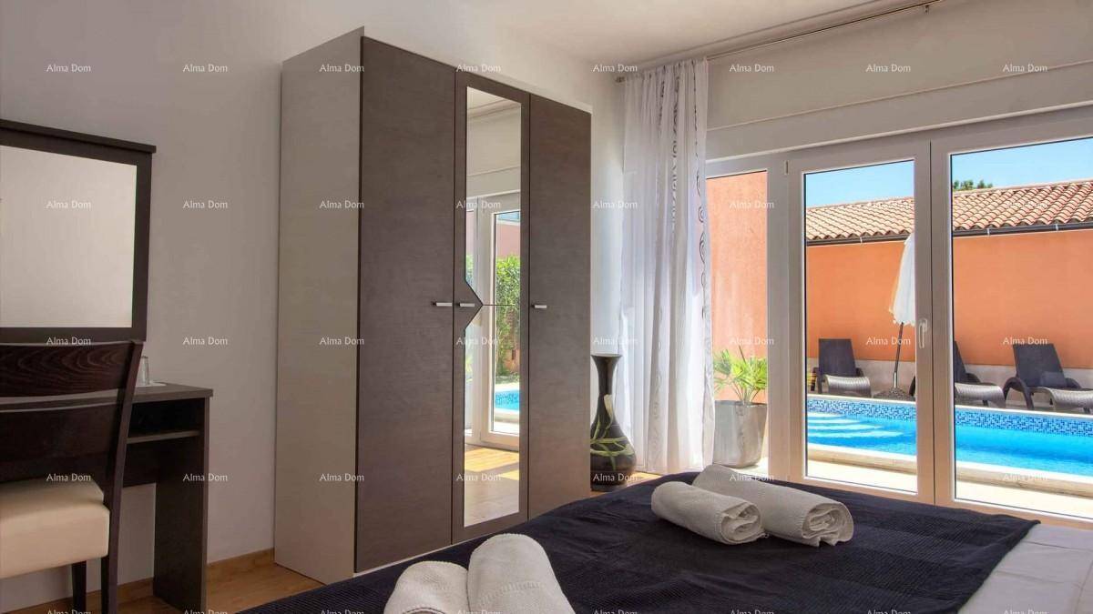 Schlafzimmer mit Doppelbett, Spiegelschrank und großen Glastüren zum Poolbereich.