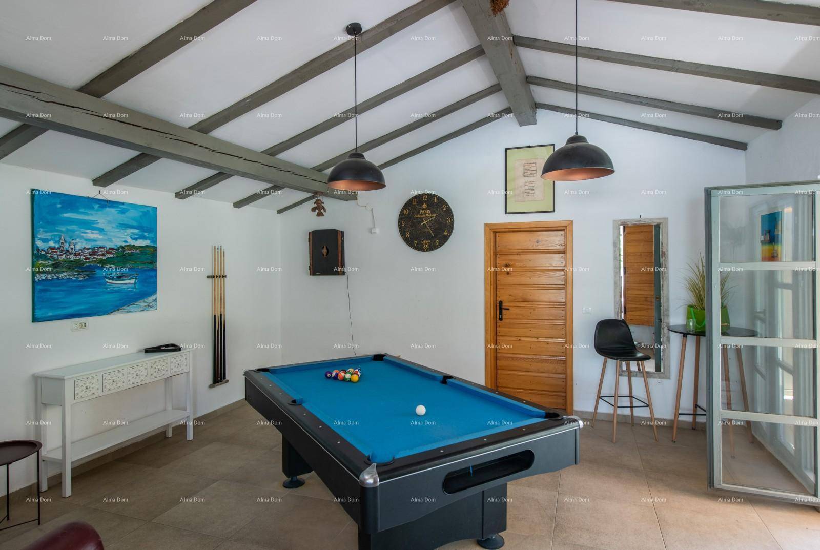 Geräumiger Spielbereich mit Billardtisch, hohen Decken und rustikalen Holzbalken.