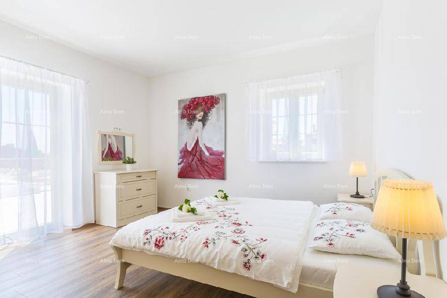 Gemütliches Schlafzimmer mit Doppelbett, Nachttischen und viel Tageslicht durch die Fenster.