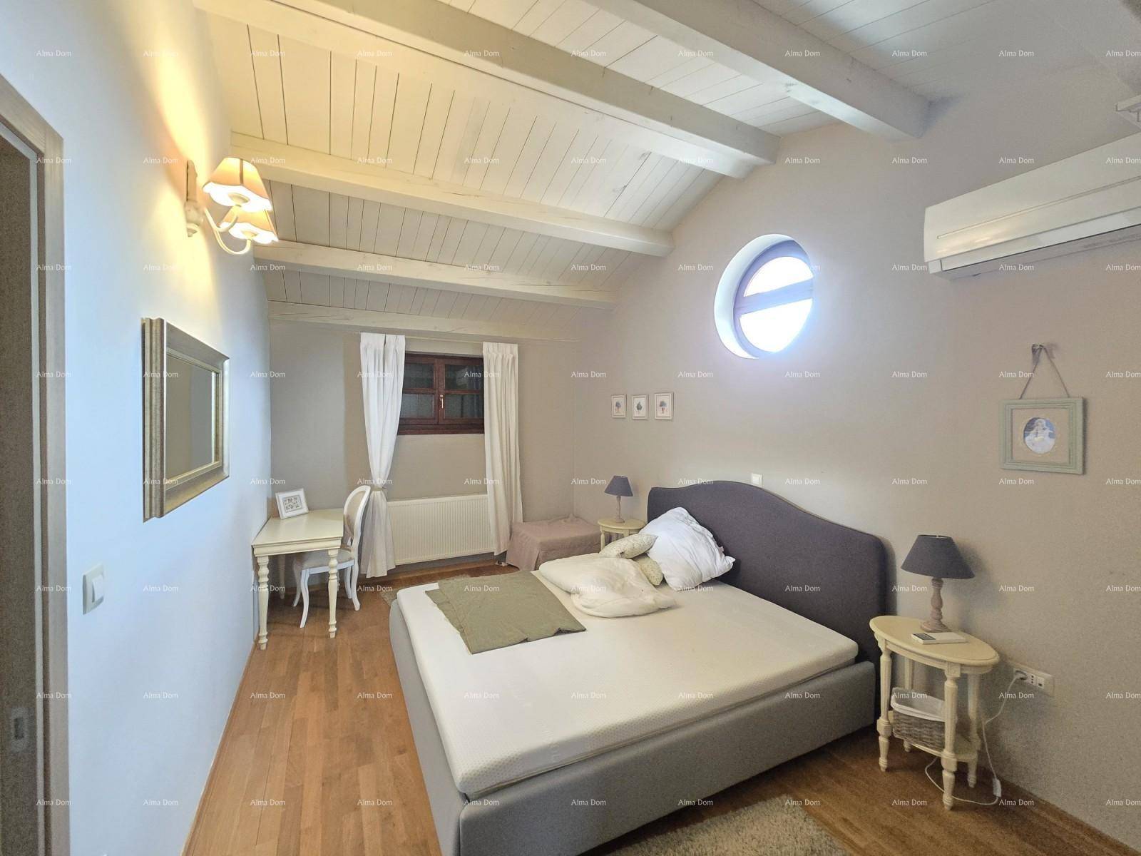 Helles Schlafzimmer mit Doppelbett, Schreibtisch, Holzboden und Klimaanlage.