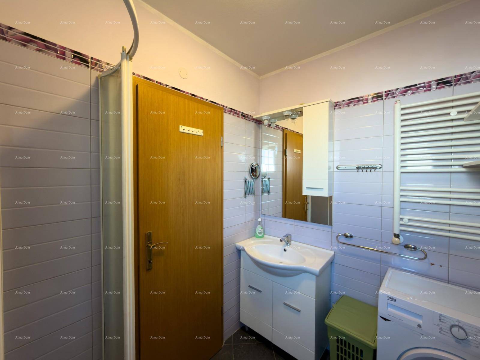 Funktionales Badezimmer mit Duschkabine, Waschbecken und beheiztem Handtuchhalter.
