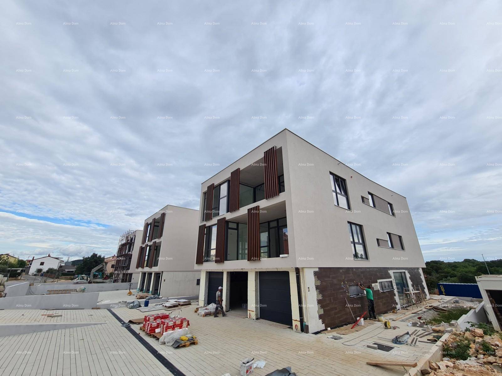 Modernes Mehrfamilienhaus im Bau mit großen Fensterfronten und Holzlamellen unter bewölktem Himmel.
