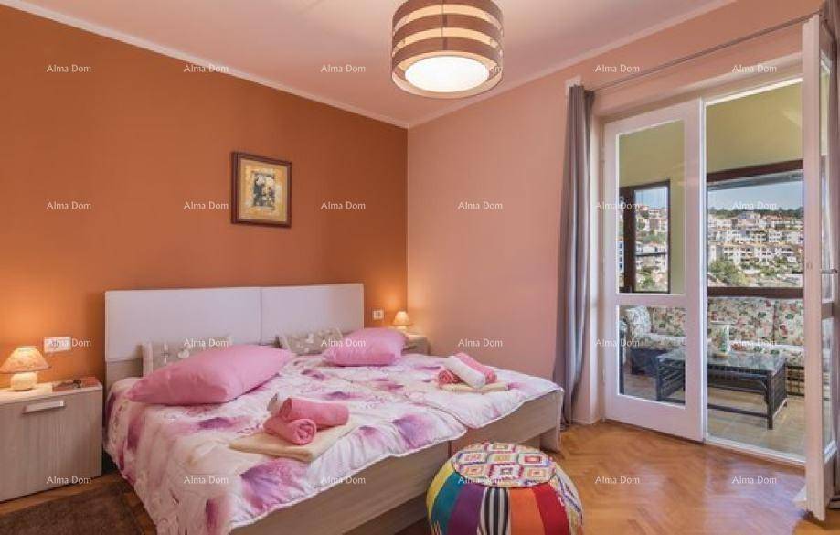 Schlafzimmer mit Doppelbett, Holzboden, brauner Akzentwand und Zugang zu einem Balkon mit Aussicht.