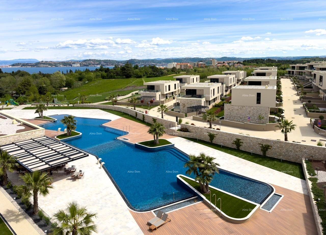 Übersicht über eine luxuriöse Wohnanlage mit mehreren Gebäuden, großem Pool und gepflegten Grünflächen unter blauem Himmel.