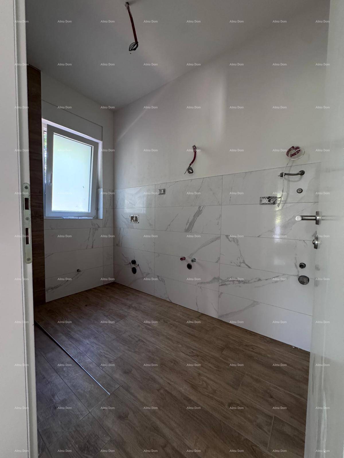 Badezimmer im Bau mit modernen Fliesen, Holzboden und einem Fenster für natürliches Licht.