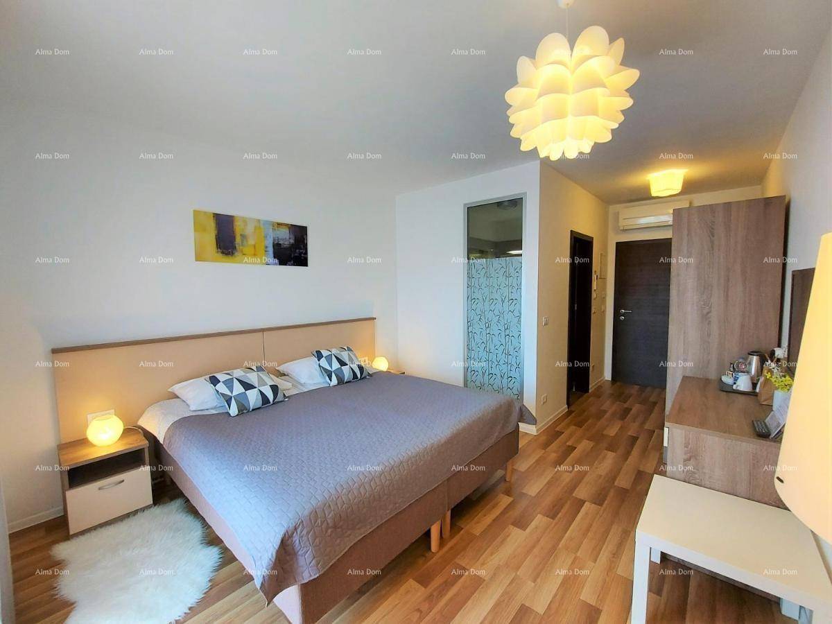 Modern eingerichtetes Schlafzimmer mit Holzboden, Doppelbett und Zugang zu einem angrenzenden Badezimmer.