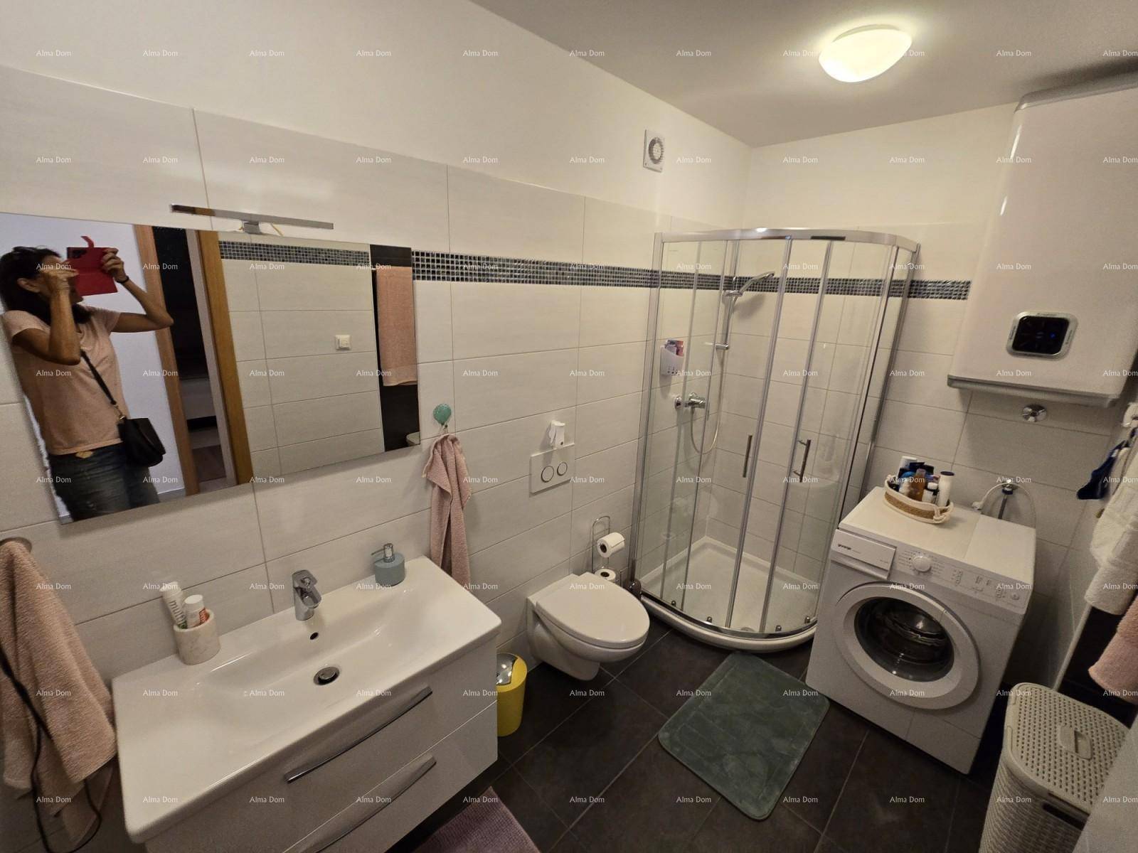 Geräumiges Badezimmer mit Duschkabine, Waschmaschine und großem Waschbecken, modern gefliest.