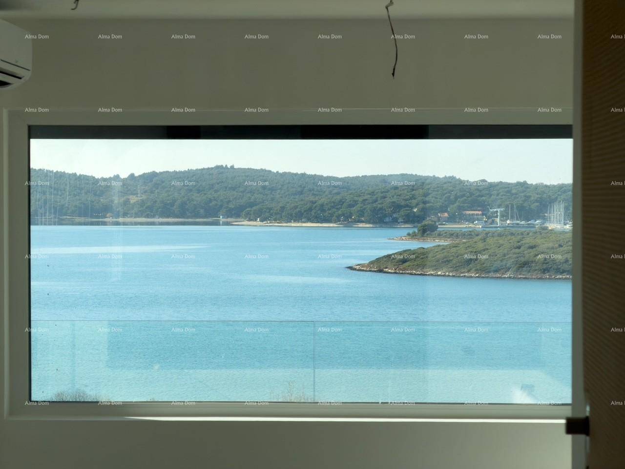 Großes Fenster bietet einen weiten Blick auf die Bucht mit Inseln und bewaldeter Küste.
