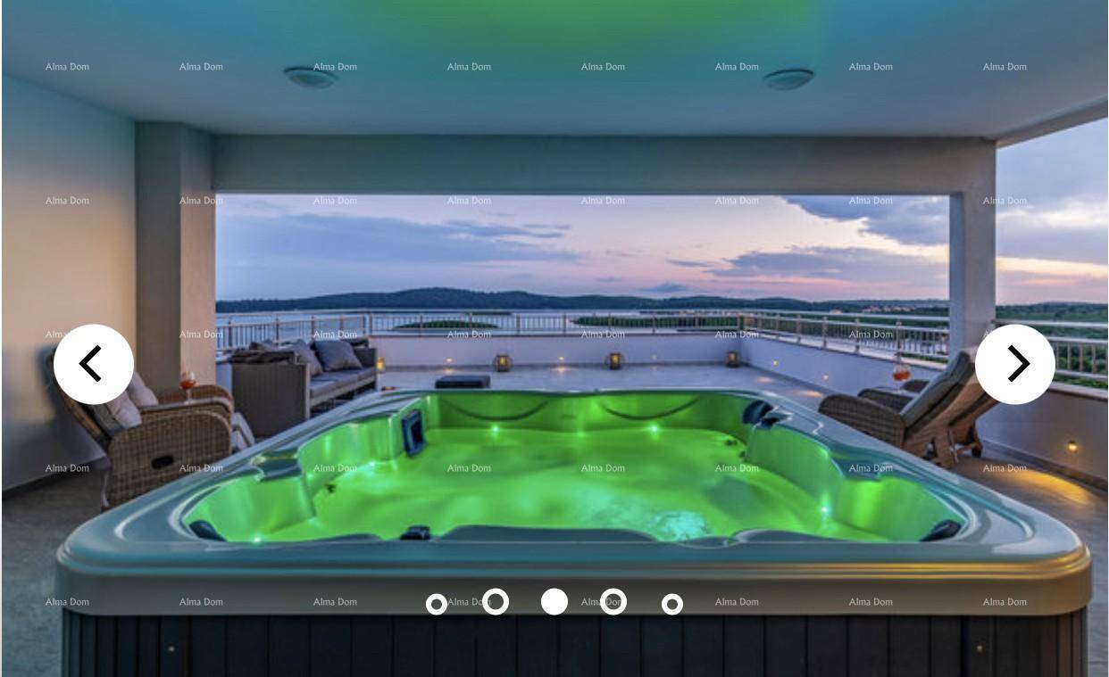 Whirlpool auf der Terrasse mit stimmungsvoller Beleuchtung und Panoramablick auf das Meer.