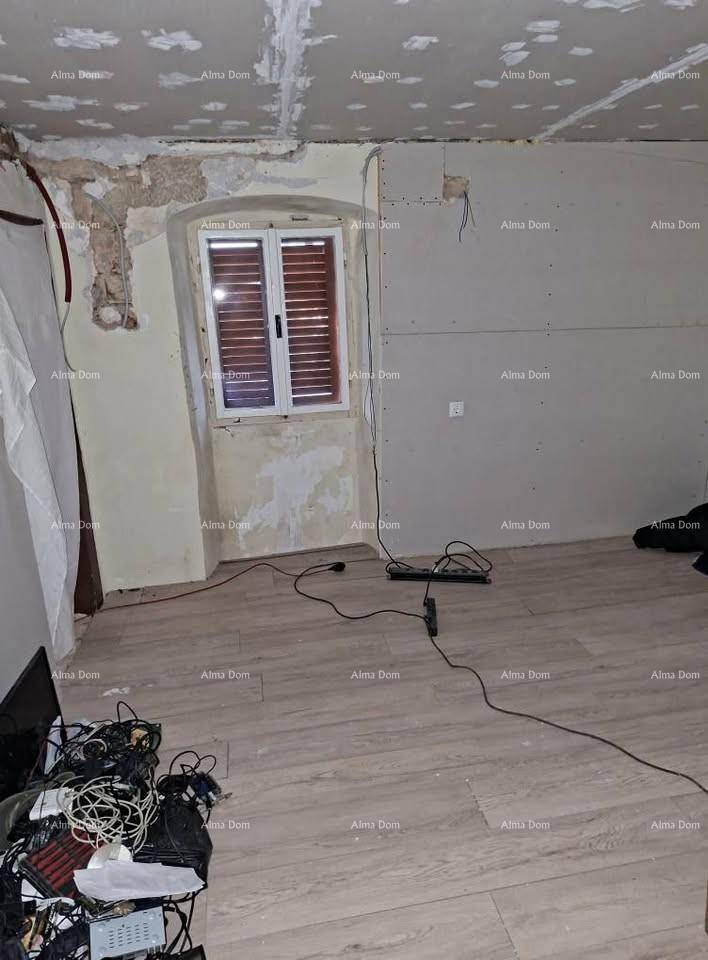 Renovierungsbedürftiger Raum mit neuem Laminatboden und freiliegenden Kabeln.