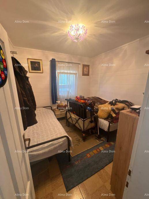 Kleines Schlafzimmer mit zwei Einzelbetten, Fenster und einfacher Einrichtung.
