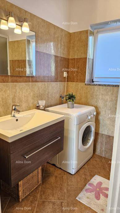 Badezimmer mit Waschbecken, Spiegel, Waschmaschine und Fenster.