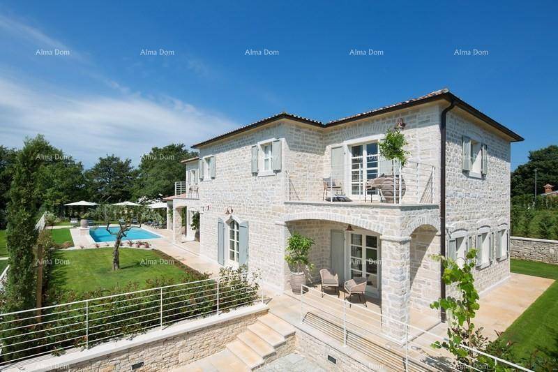 Elegantes Steinhaus mit mehreren Balkonen und einem weitläufigen Gartenbereich mit Pool.