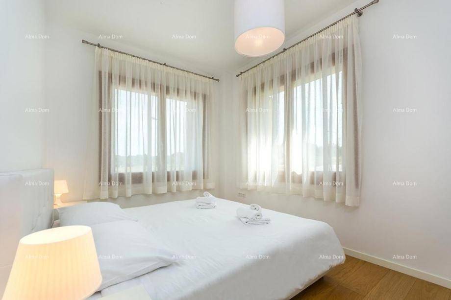 Helles Schlafzimmer mit Doppelbett, Parkettboden und zwei Fenstern.
