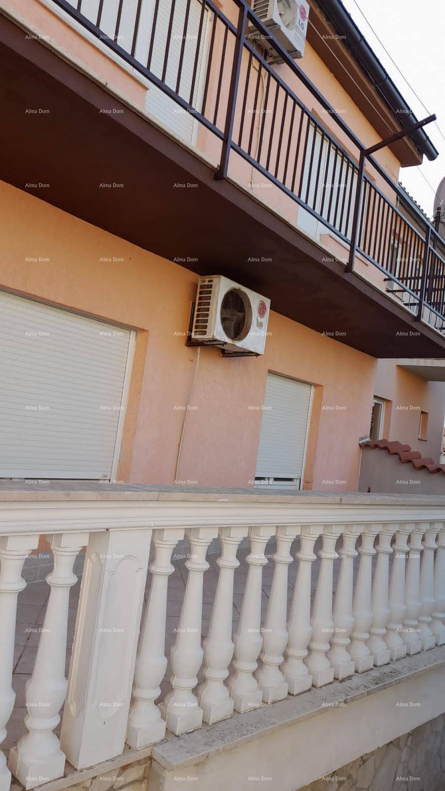 Fassade eines Gebäudes mit Balkonen, Rollläden und Klimaanlagen, umgeben von einer Balustrade.