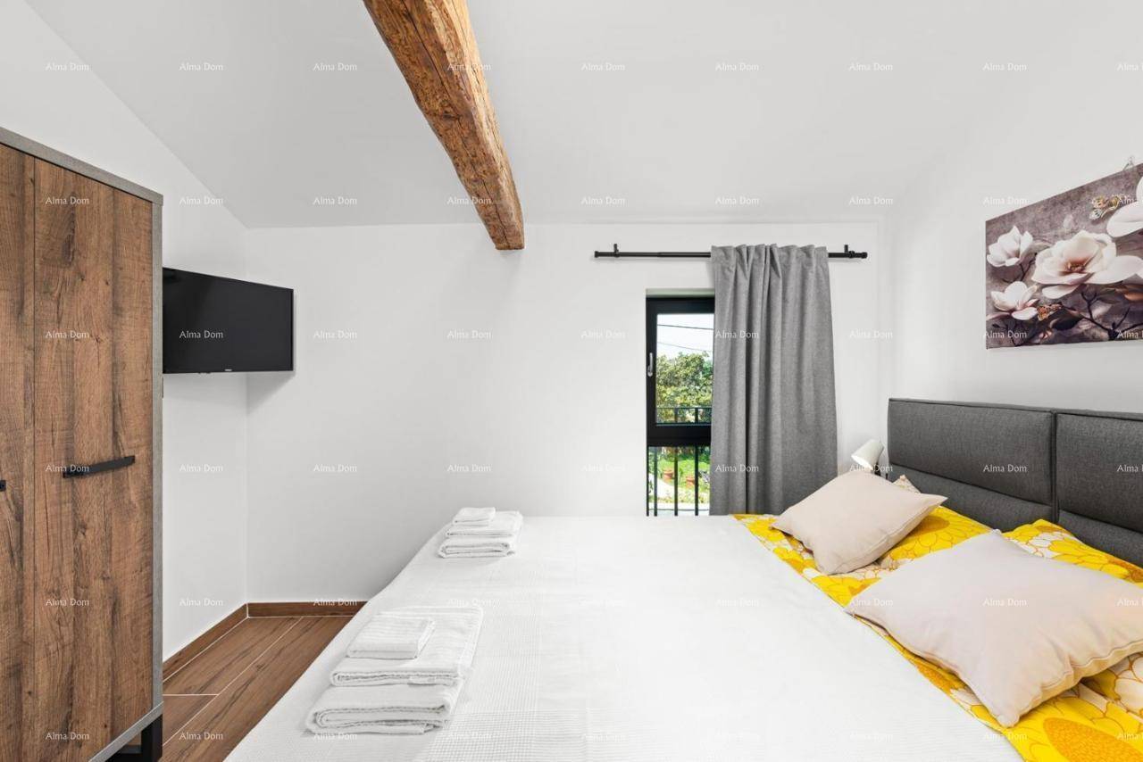 Gemütliches Schlafzimmer mit Holzbalken, Holzkleiderschrank und Blick ins Grüne.