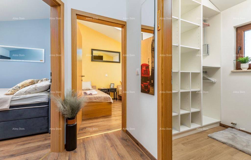 Heller Flur mit Holzfußboden und offenem Kleiderschrank, der zu den Schlafzimmern führt.