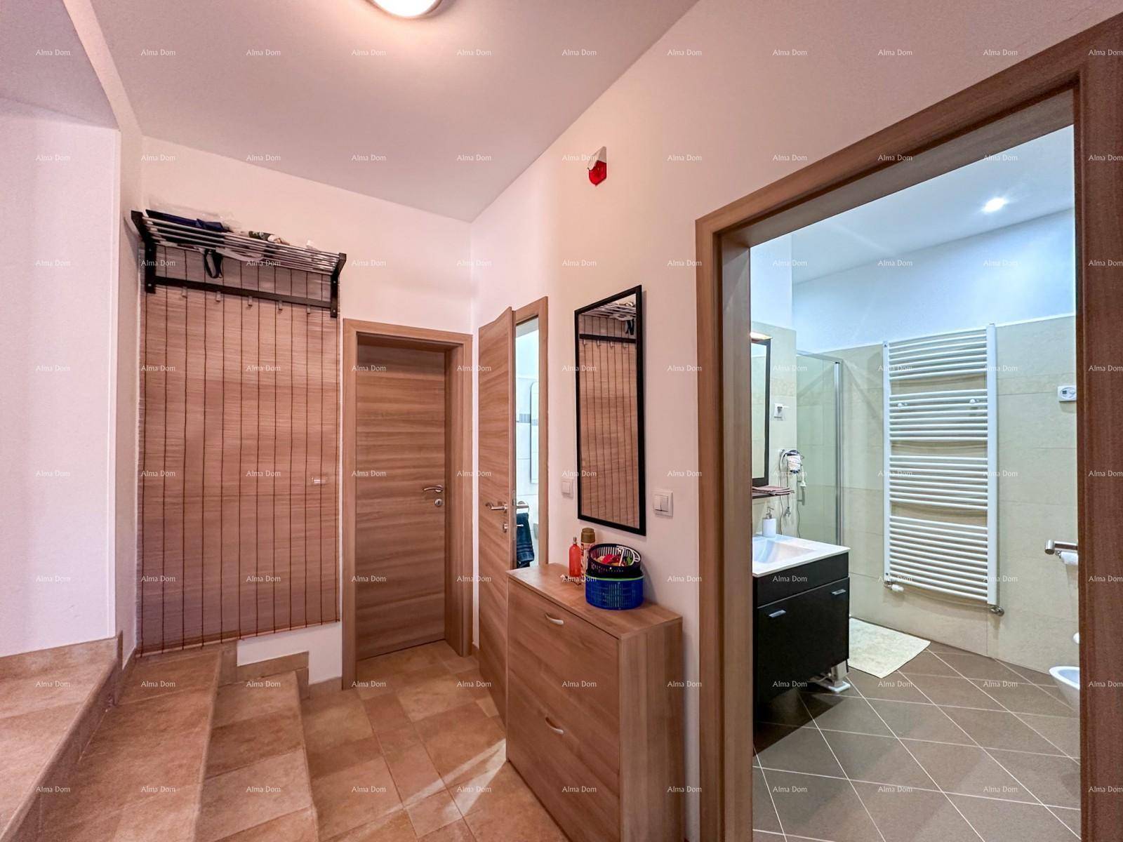 Eingangsbereich mit Garderobe, Schuhschrank und Blick in ein modernes Badezimmer.