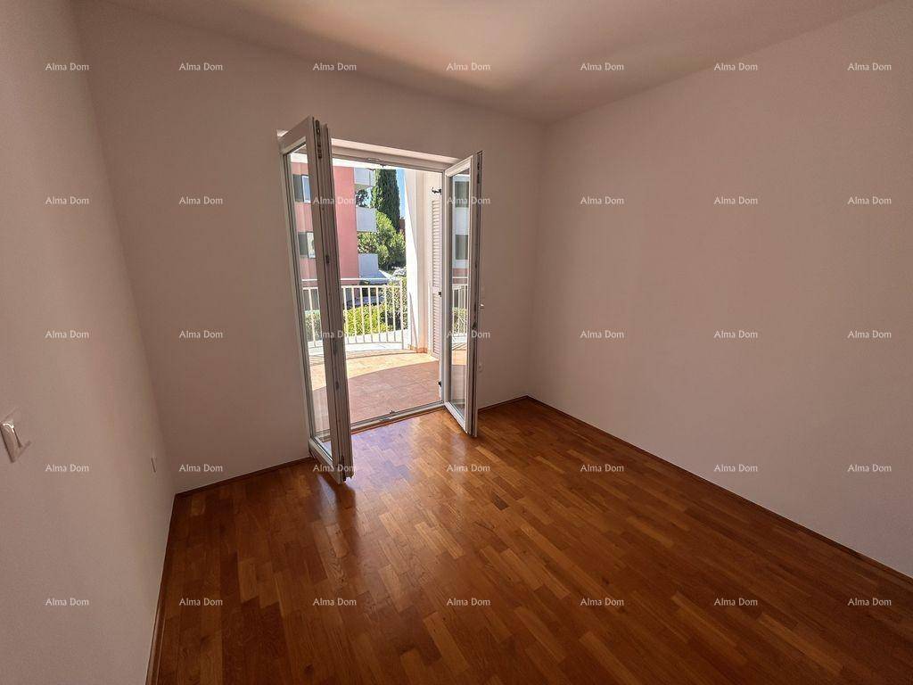 Schlafzimmer mit elegantem Parkettboden und direktem Zugang zu einem sonnigen Balkon.