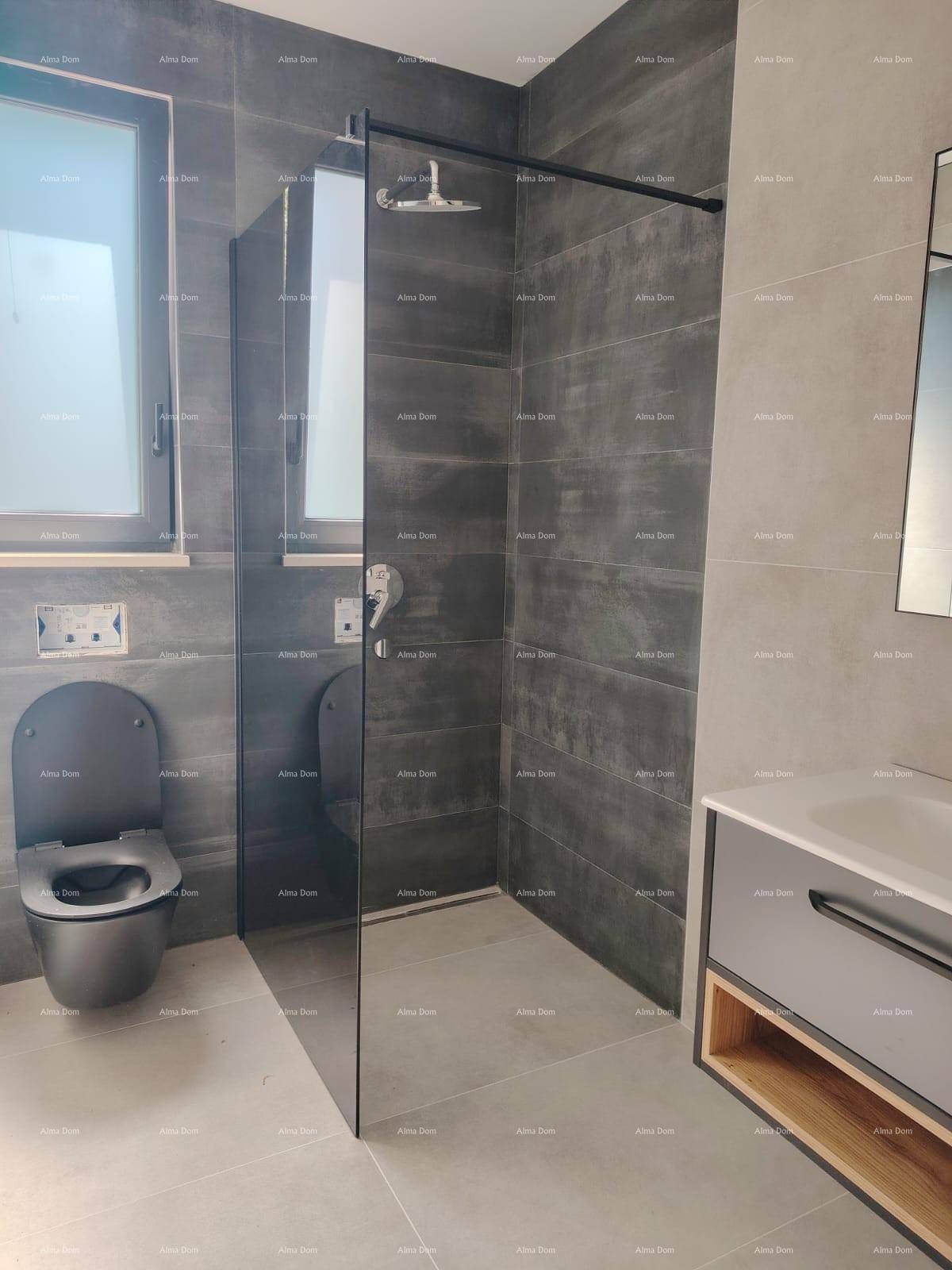 Modernes Badezimmer mit grauen Fliesen, bodengleicher Dusche und wandhängendem WC.