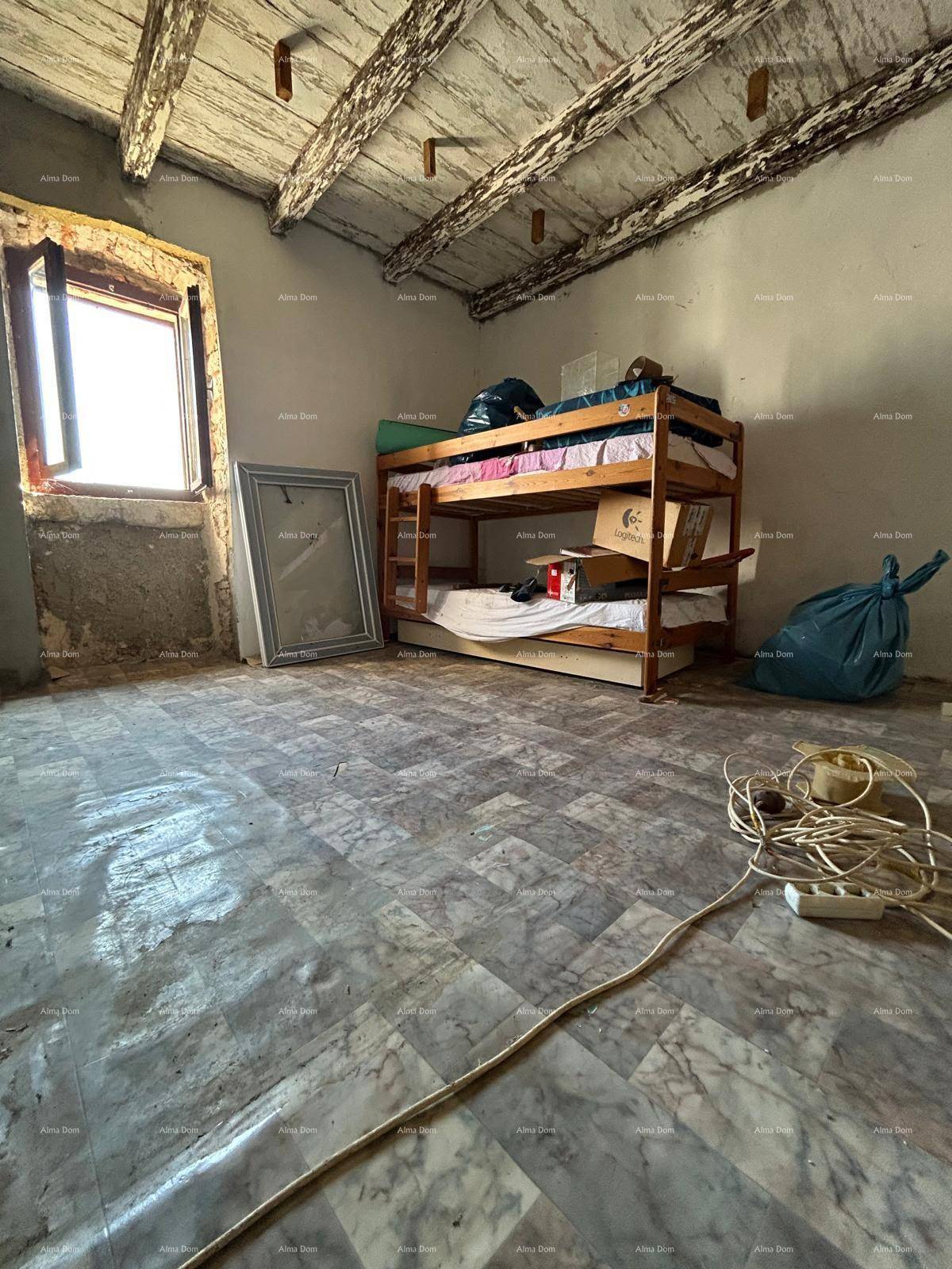 Schlafzimmer im Rohbau mit Etagenbett, sichtbaren Holzbalken und Fliesenboden.