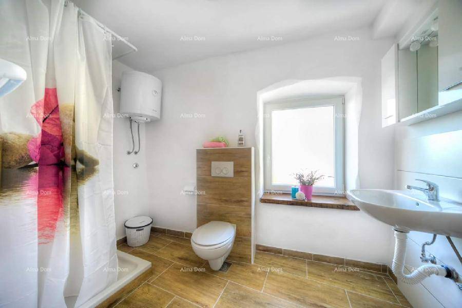 Badezimmer mit Duschbereich, WC, Waschbecken und Fenster für gute Belüftung.