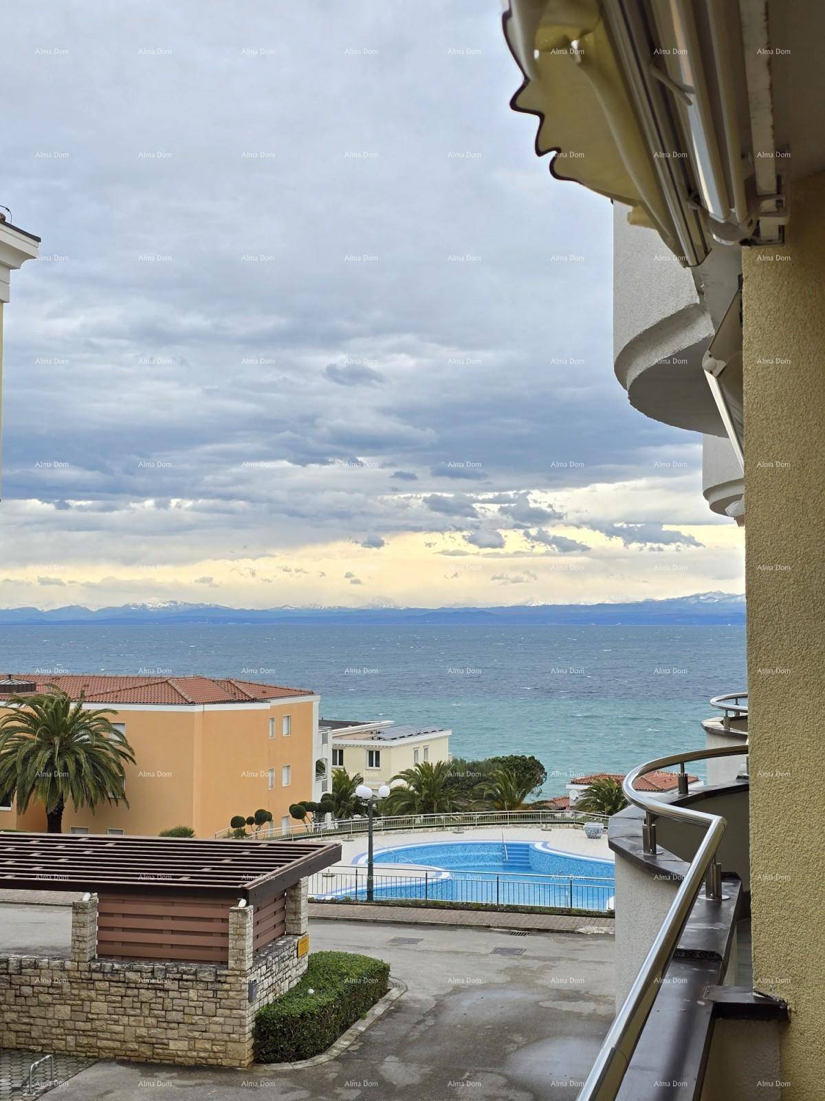 Panoramablick vom Balkon auf das weite Meer, die Berge und den Gemeinschaftspool der Anlage.
