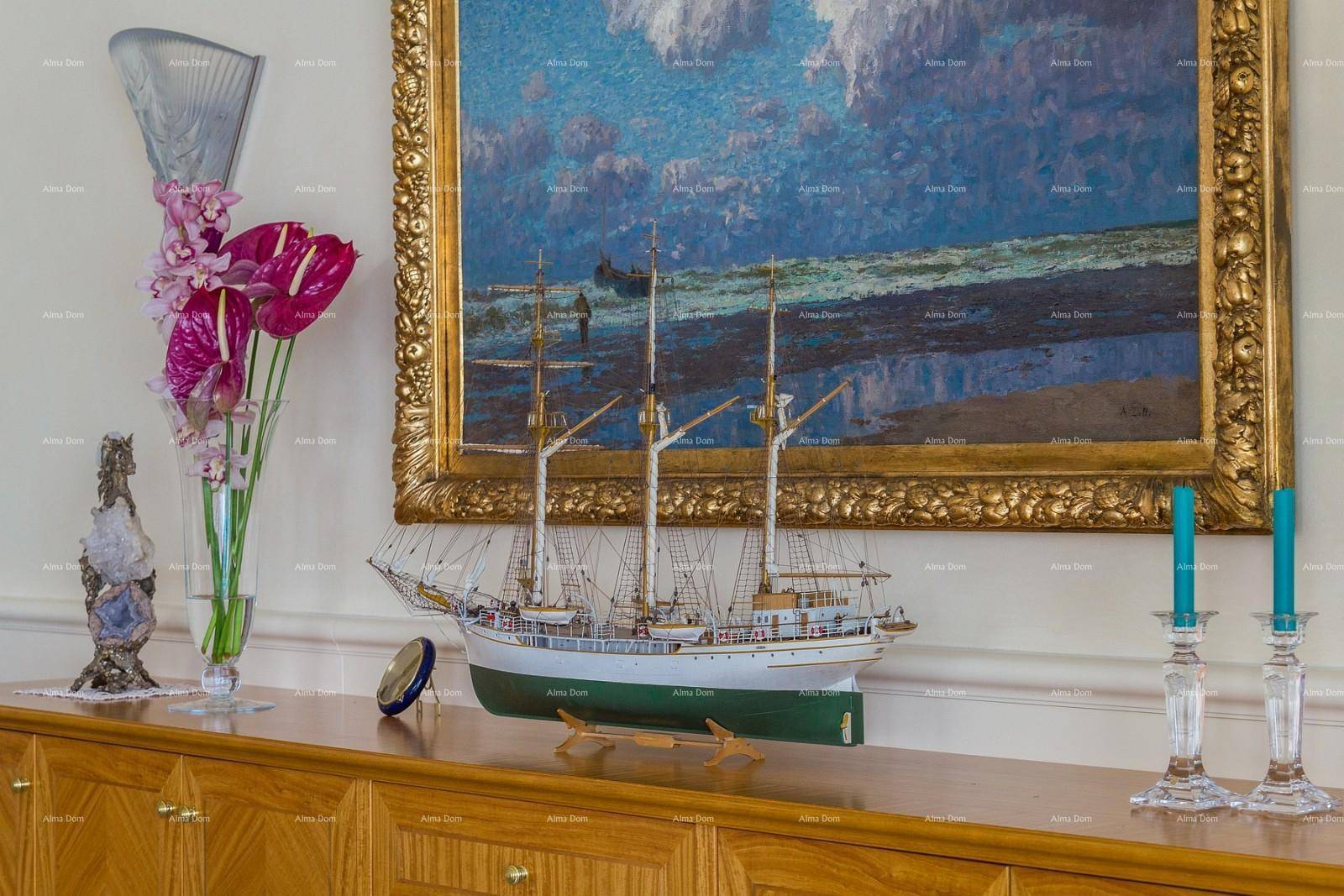 Detailansicht eines Sideboards mit Schiffsmodell und Kunstwerk in einem eleganten Wohnbereich.