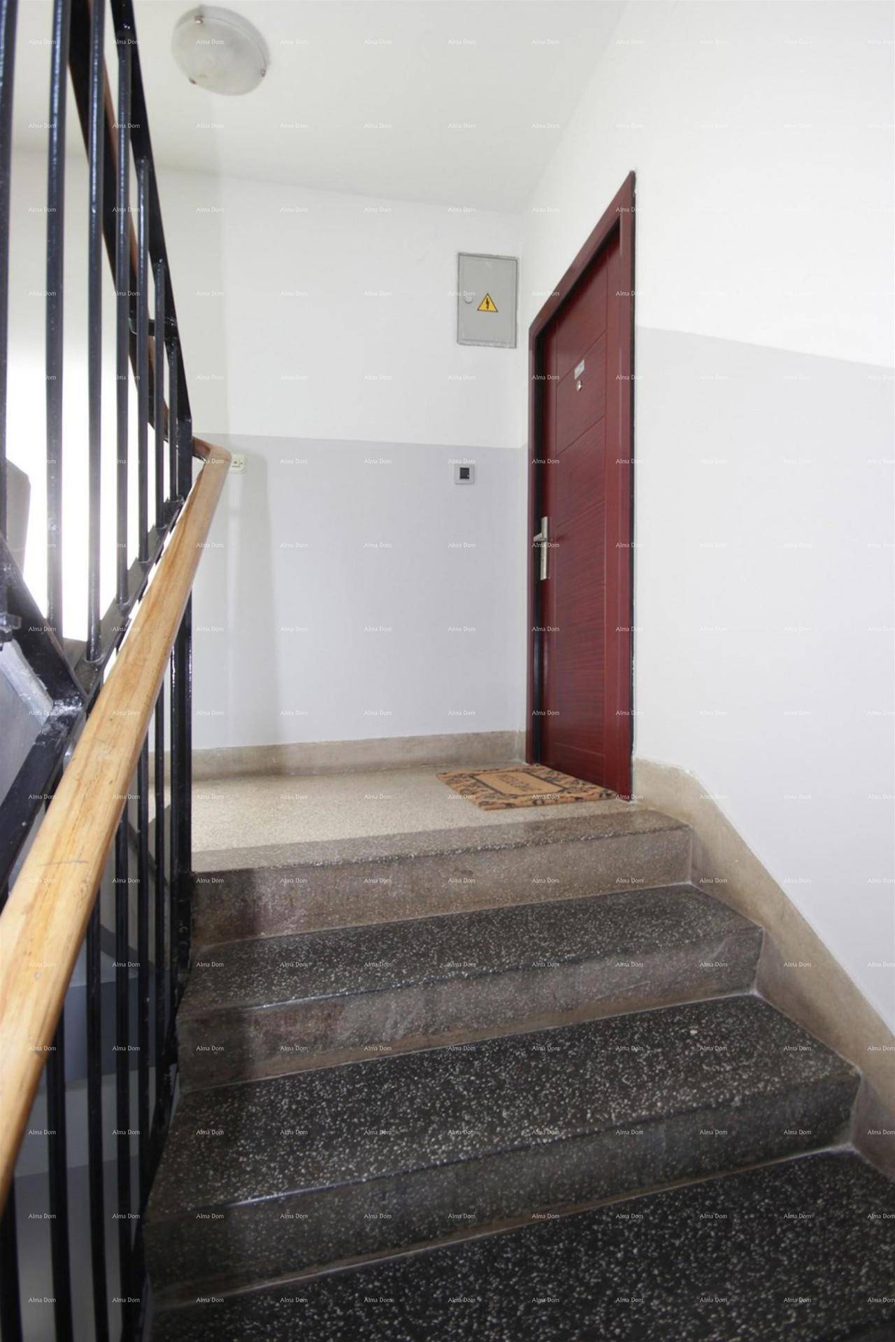 Treppenhaus mit Steinstufen und Holzgeländer, führt zur Wohnungstür.