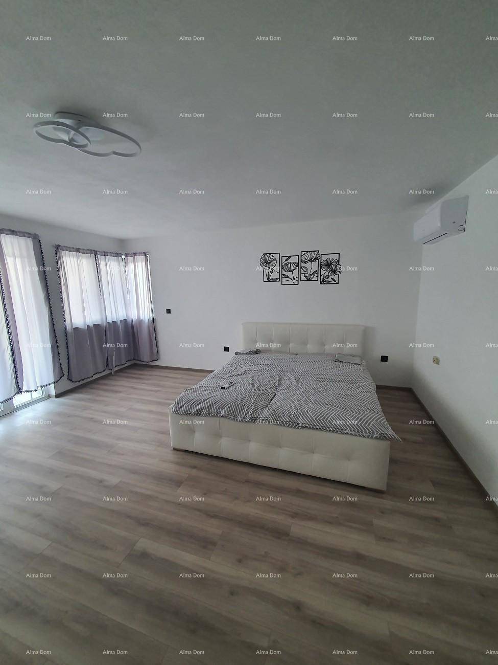 Geräumiges Schlafzimmer mit Doppelbett, Laminatboden und Klimaanlage, hell und modern eingerichtet.