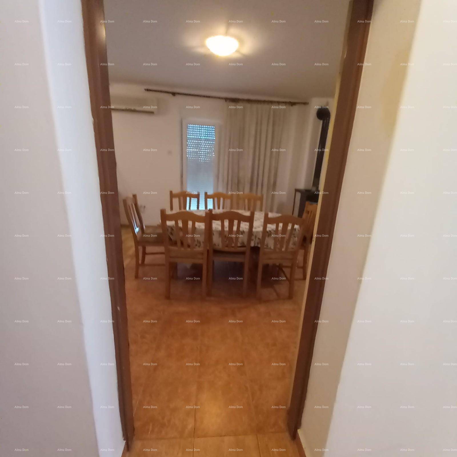 Blick vom Wohn- und Essbereich durch eine offene Tür auf den Balkon und die Umgebung.