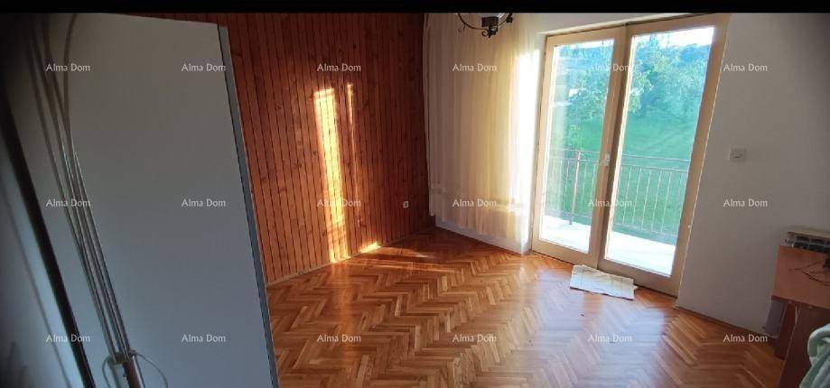 Helles Zimmer mit Parkettboden und Holzwandverkleidung, mit Zugang zu einem französischen Balkon.