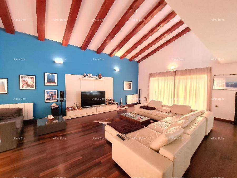 Modernes Wohnzimmer mit blauer Akzentwand, Holzbalken und großem Sofa.