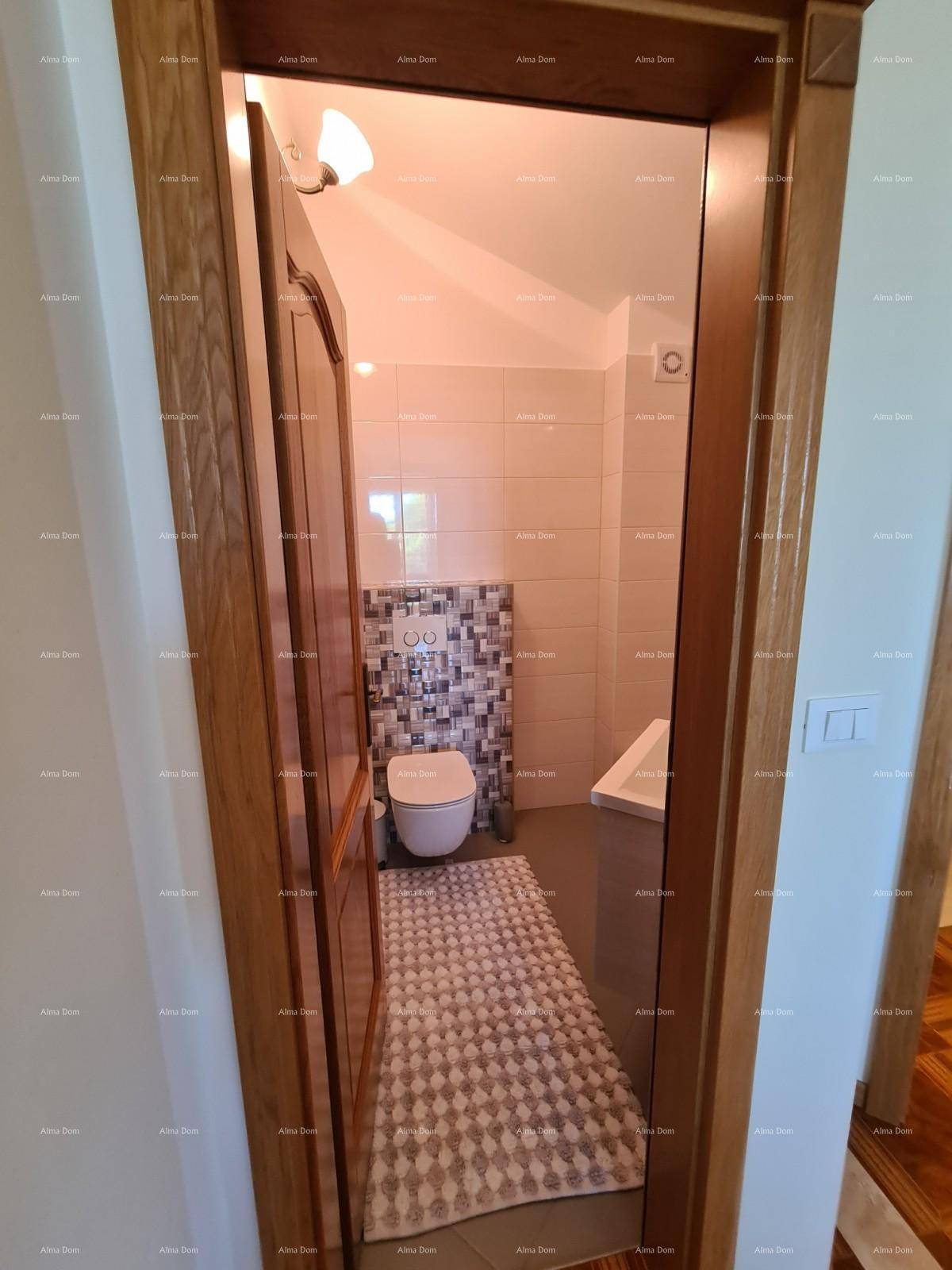 Kleines Gäste-WC mit Toilette, Bidet-Brause und modernen Fliesen an den Wänden.