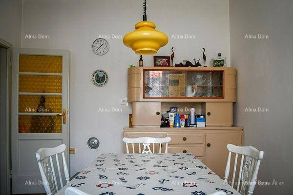 Esszimmer mit Esstisch, Stühlen und einem traditionellen Buffetschrank unter einer gelben Lampe.