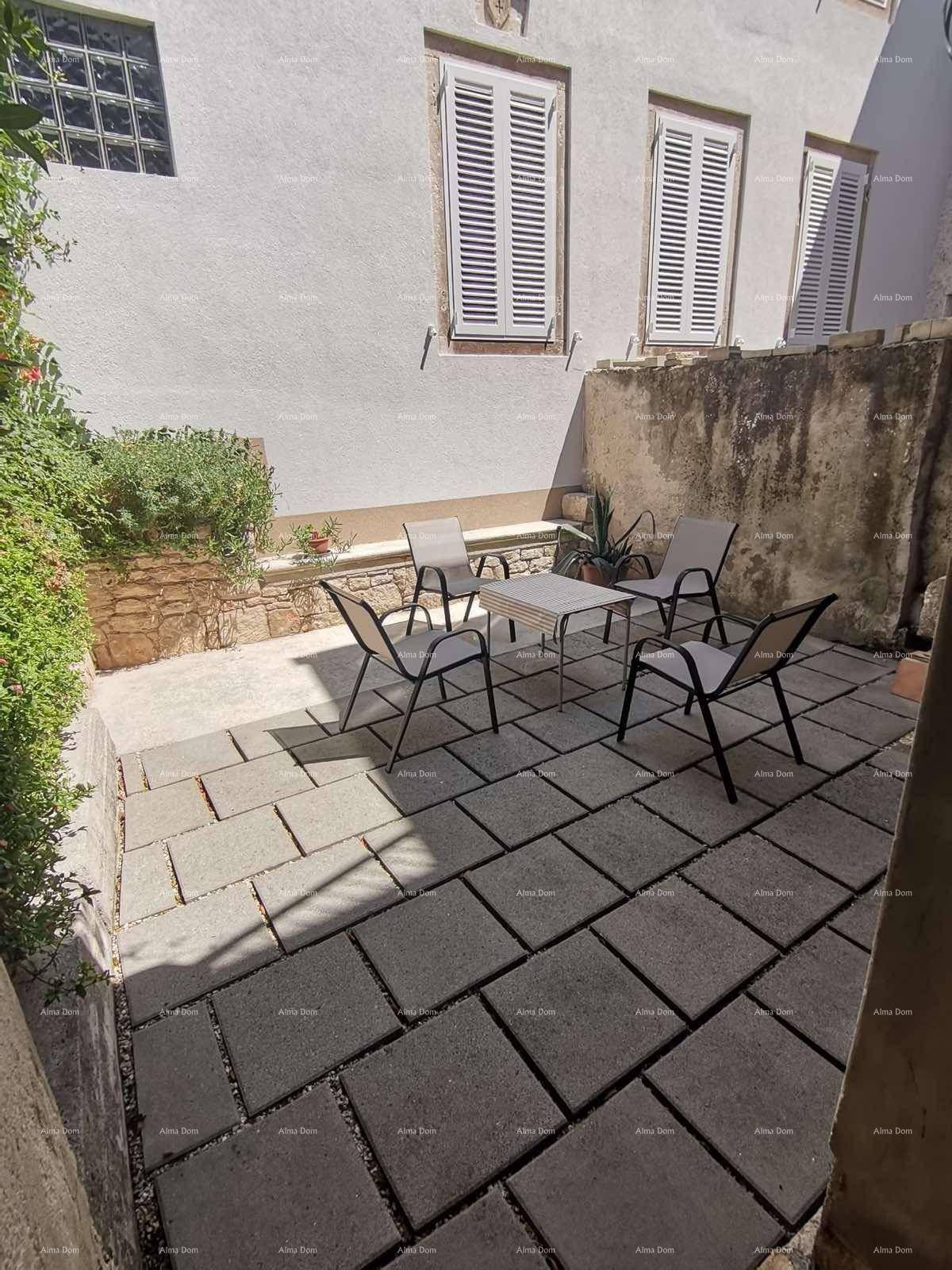 Gepflasterte Terrasse mit Gartenmöbeln und ummauerten Blumenbeeten.