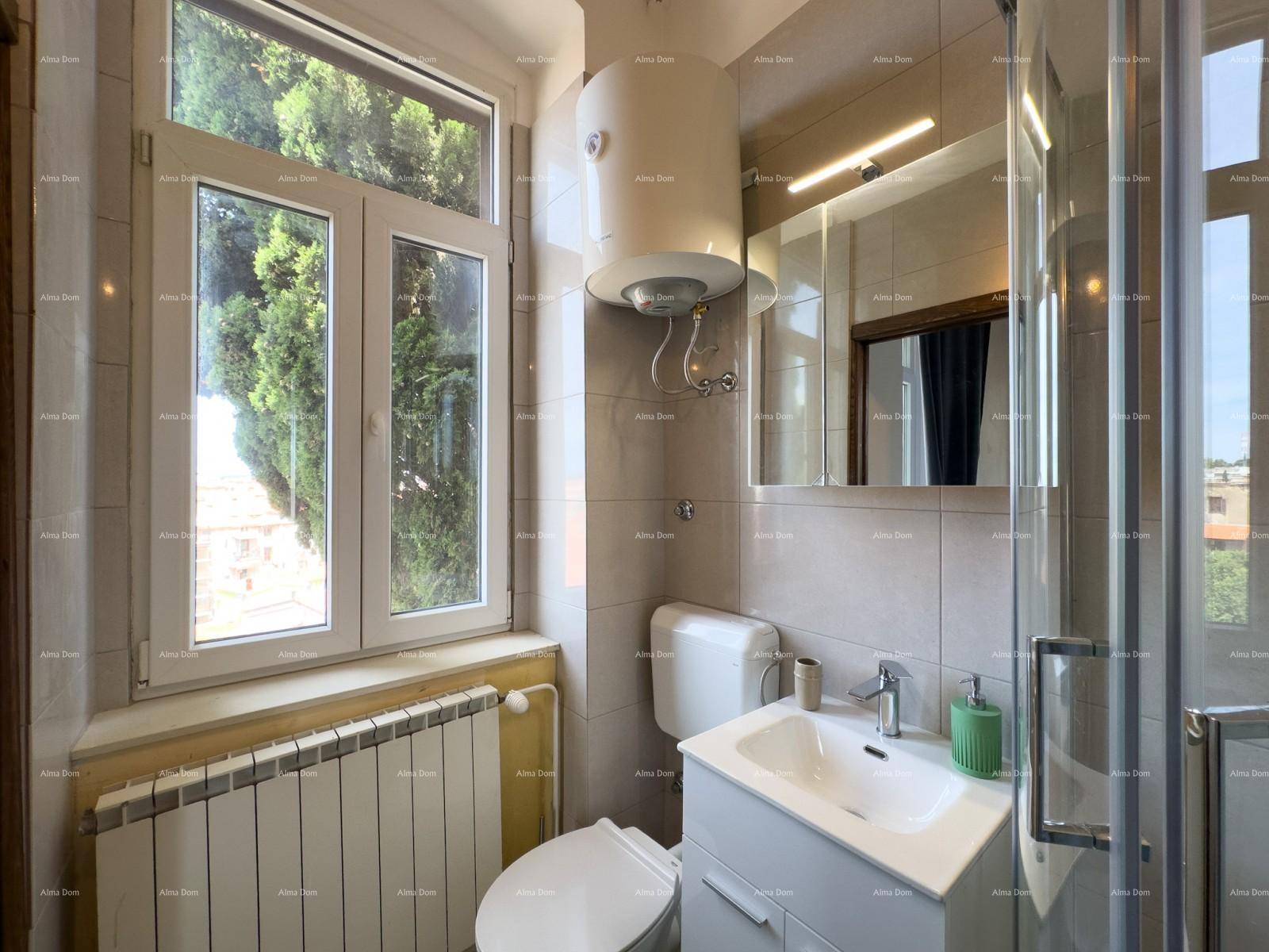 Helles Badezimmer mit Fenster, Duschkabine, WC und Waschbecken mit Spiegelschrank.