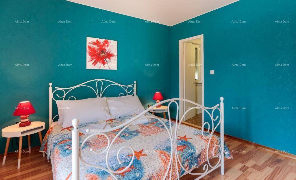 Schlafzimmer mit Doppelbett, blauer Akzentwand und Holzboden.