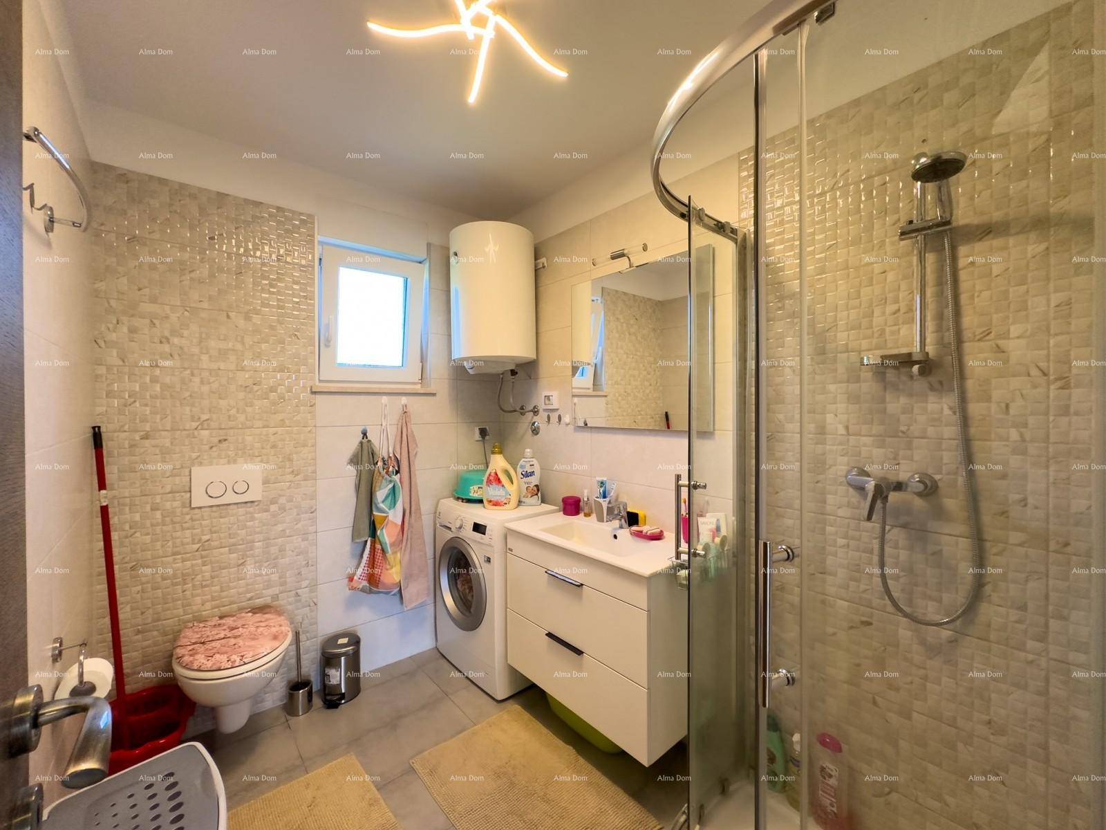 Modernes Badezimmer mit Dusche, WC, Waschbecken und Waschmaschine, mit Fenster.