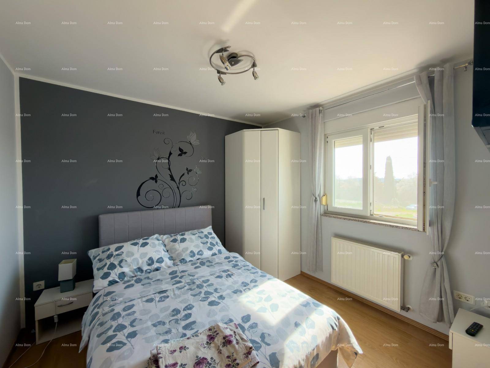 Schlafzimmer mit Doppelbett, Kleiderschrank und Fenster für natürliche Belichtung.