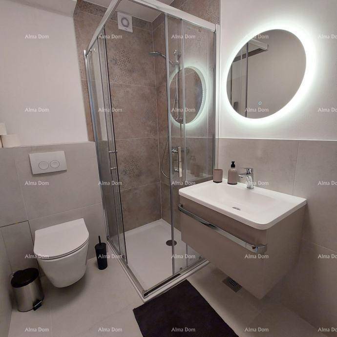 Modernes Badezimmer mit begehbarer Dusche, Hänge-WC und beleuchtetem Spiegel über dem Waschtisch.