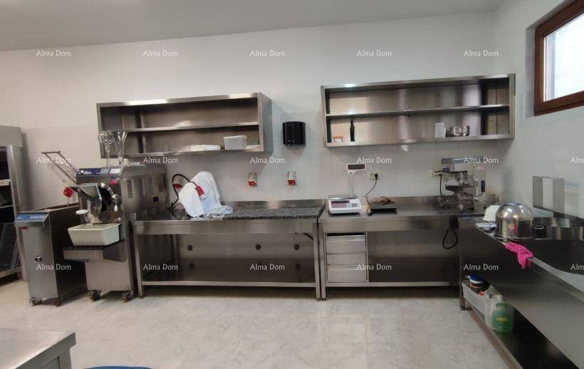 Professionelle Edelstahlküche mit Arbeitsflächen, Regalen und Geräten für Gastronomie.