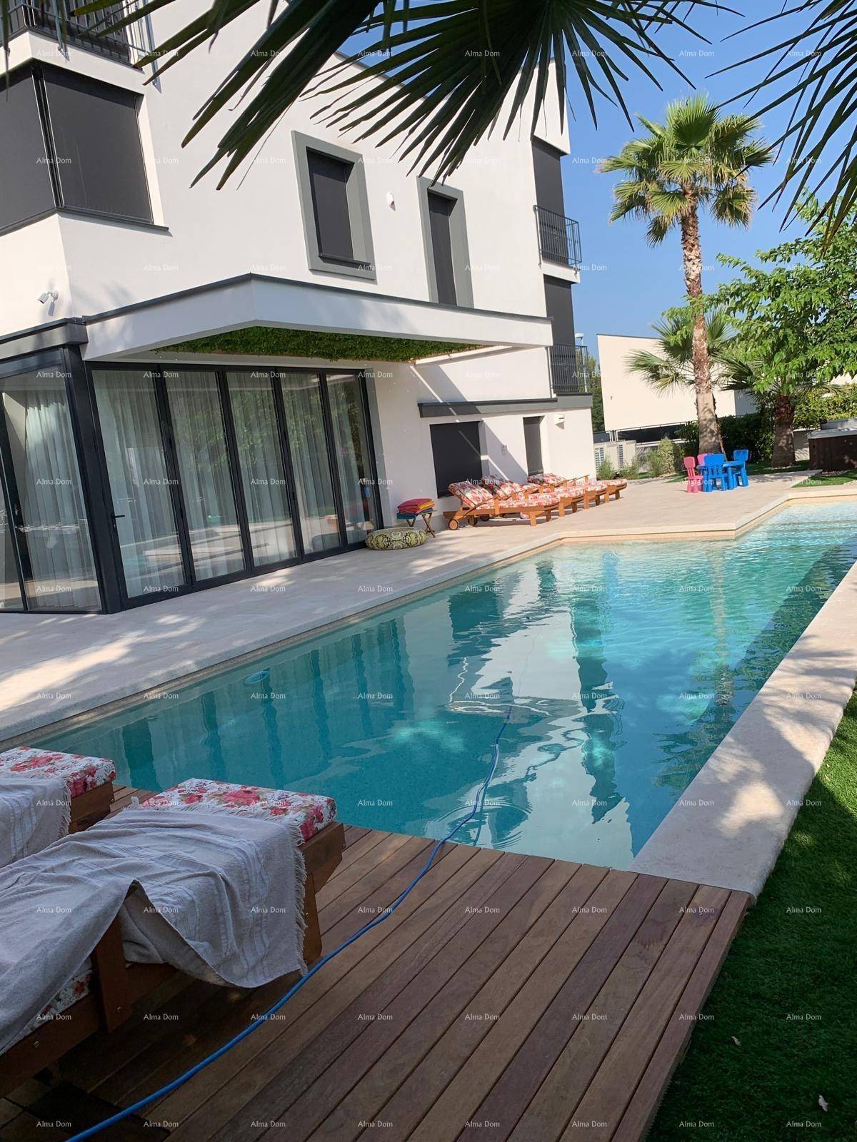 Moderner Außenbereich mit großem Pool, Holzdeck und Liegestühlen unter Palmen.
