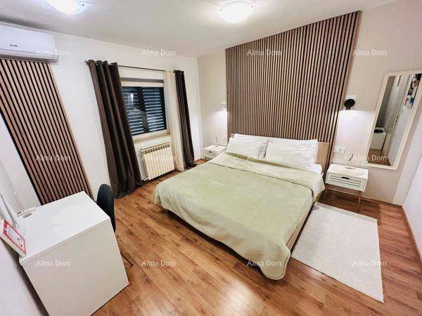 Helles Schlafzimmer mit Holzboden, vertikaler Holzverkleidung und einem praktischen Schreibtisch.